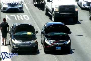 Two vehicles with hoods open in the right lane