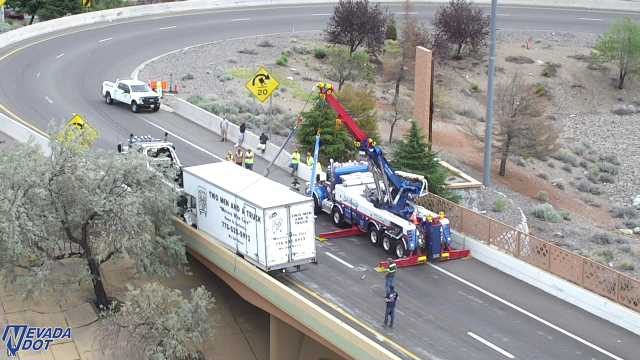 Tow truck assisting a semi-trailer truck on the right shoulder