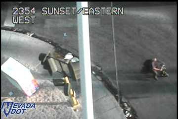 Person sitting on the side of the roadway
