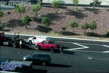 Tow truck assisting a red pickup truck in the right lane