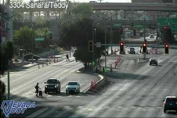 Pedestrian walking in the roadway/crosswalk on the left in front of a black SUV