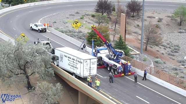 Tow truck assisting a semi-trailer truck on the roadway