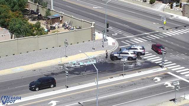 Debris and liquid spill in the roadway with two police vehicles present