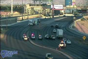 Multiple police cars with lights on in the right lane and shoulder