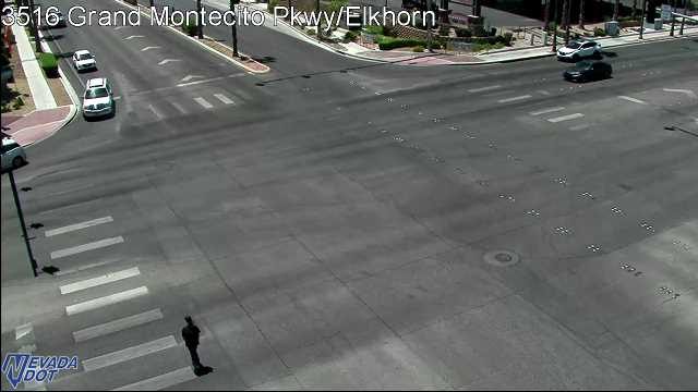 Pedestrian walking in the crosswalk in the bottom left