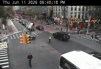 Police officer directing traffic at an intersection with a downed traffic light pole.