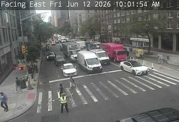 Traffic controller directing traffic at an intersection with multiple vehicles.