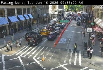Traffic incident with a responder directing traffic and cones on the road.
