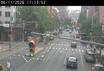 Traffic light pole has fallen across the roadway, obstructing traffic.
