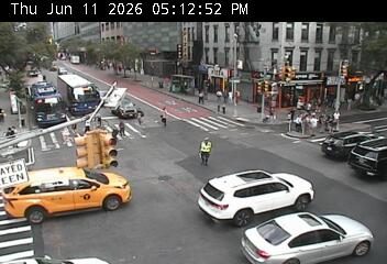 Person in reflective vest directing traffic at an intersection.