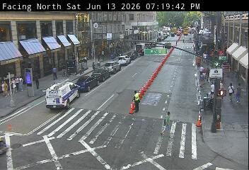 Police vehicle and officer present, traffic cones indicate a potential incident response.