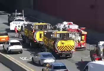 Emergency responders and vehicles are present on the roadway.