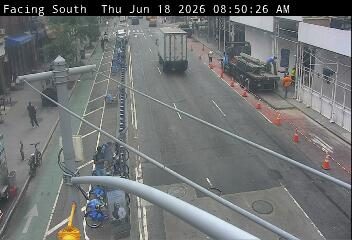 Construction crew and truck on the side of the road with cones.
