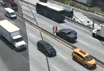 Two people in safety vests appear to be responding to something on the highway.