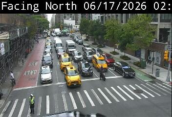 Traffic officer directing traffic at an intersection with multiple vehicles.