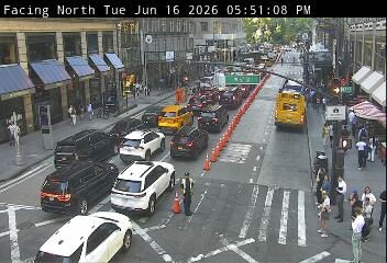 Police officer directing traffic in a busy intersection with heavy traffic.
