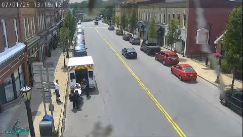 Ambulance with personnel attending to a patient on a stretcher on the side of the road