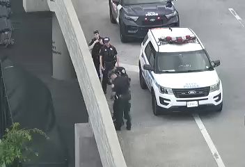 Police officers and vehicles are present on the roadway.