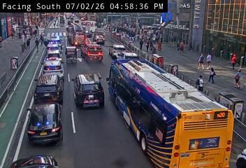 Multiple police cars and fire trucks with lights on in the left lanes