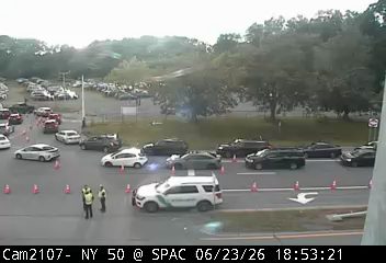 Two police officers and a police SUV with lights on in the roadway