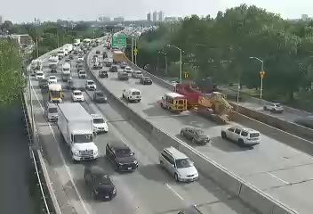 Construction vehicles and equipment on the side of the highway, possibly blocking traffic.