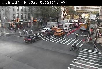 Police officer directing traffic at an intersection with multiple vehicles.