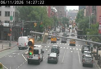 A traffic light pole has fallen across the roadway, obstructing traffic.