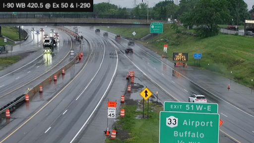 Emergency responders and vehicles are present on the wet roadway, directing traffic.