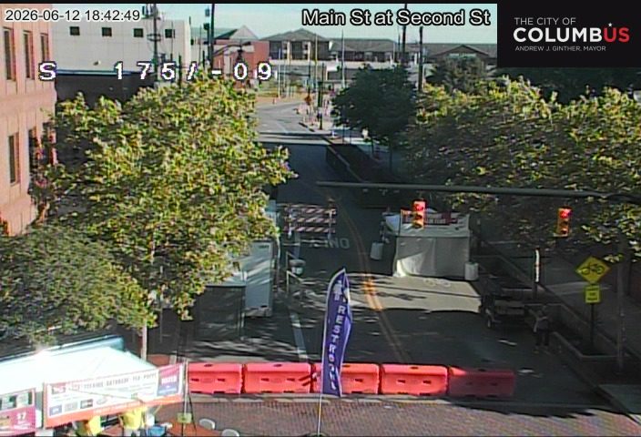 Road closure with barriers and tents, possibly for an event or construction.