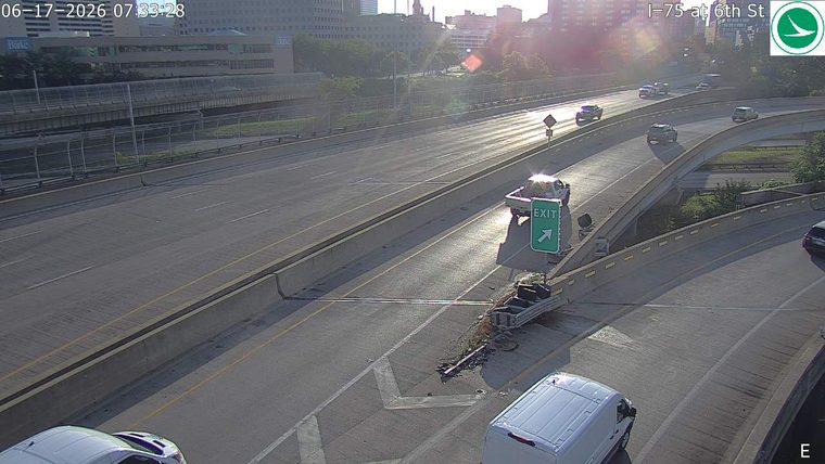 A trailer has detached and spilled debris onto the roadway near an exit.