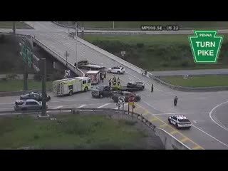Emergency responders and vehicles at a multi-vehicle crash scene on a highway overpass.