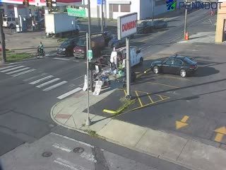 Police car and personnel at intersection with debris on roadway.