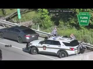 Police officers are present at a roadside incident with two vehicles.
