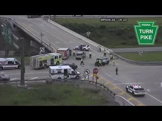 Multiple emergency vehicles and personnel on the roadway, indicating an incident response.