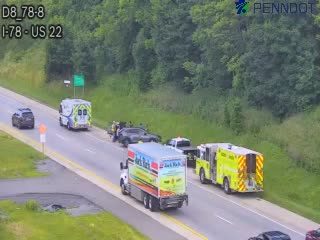 Emergency responders and vehicles are present at a roadside incident.
