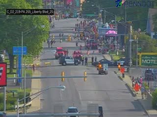 Police and emergency vehicles present on roadway with personnel and cones.