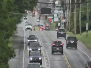 Emergency responders are on the scene with flashing lights and cones blocking traffic.