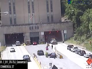 Emergency responders are present at the tunnel entrance with vehicles and personnel.
