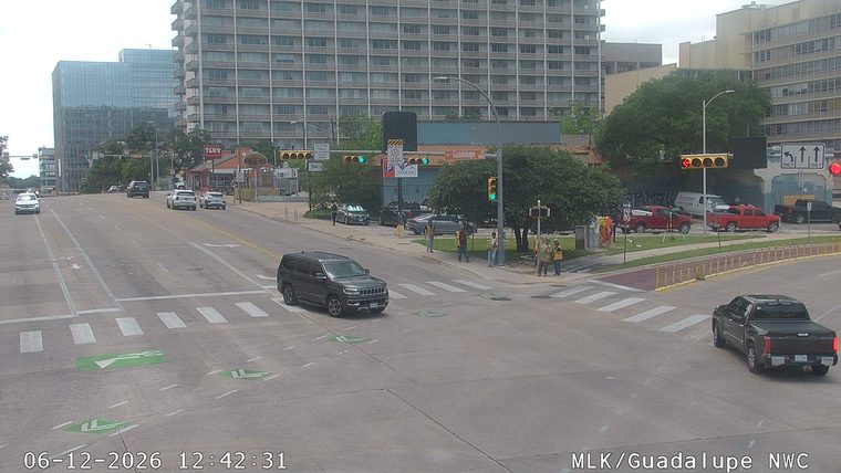 Several workers in high-visibility vests are present near the intersection.