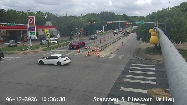Construction workers and equipment are present on the roadway, indicating ongoing work.