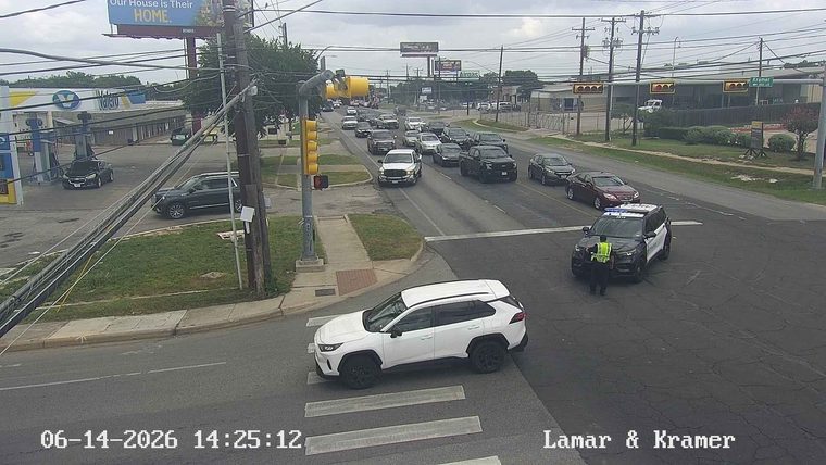 Police officer directing traffic at an intersection with a police SUV present.