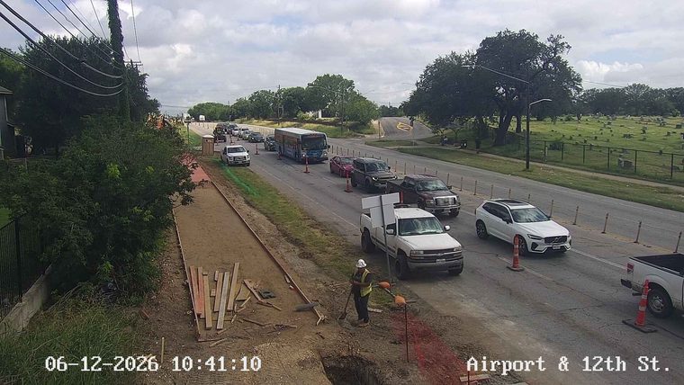 Construction worker with safety vest and hard hat on roadway.