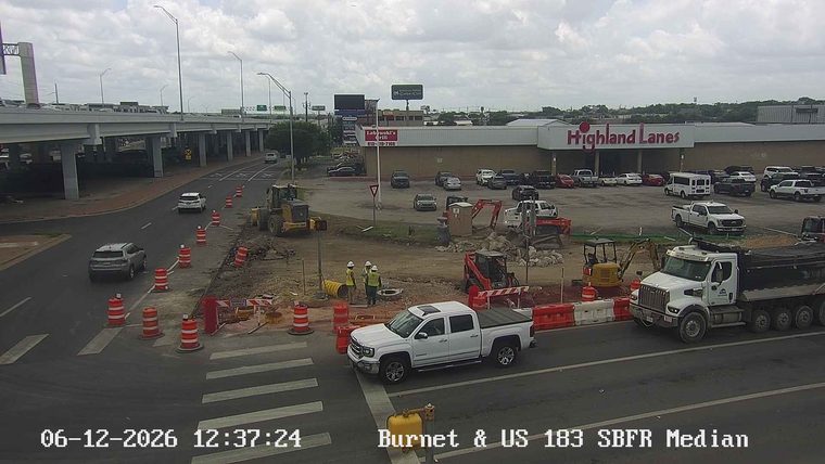 Construction workers and equipment on the roadway indicate an incident.