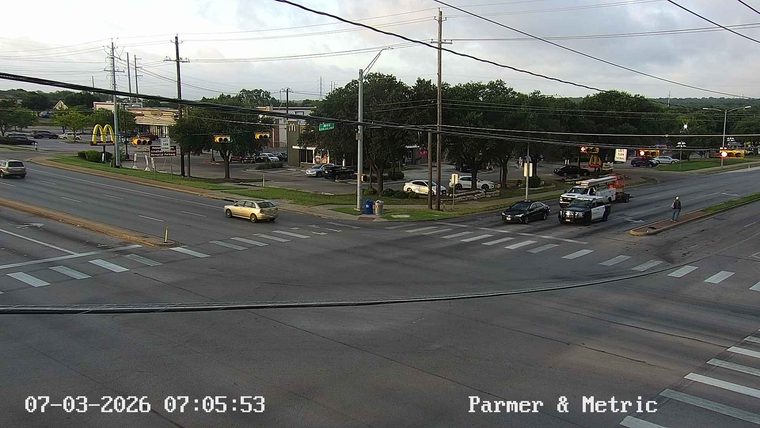 Police car and fire truck with lights on at intersection