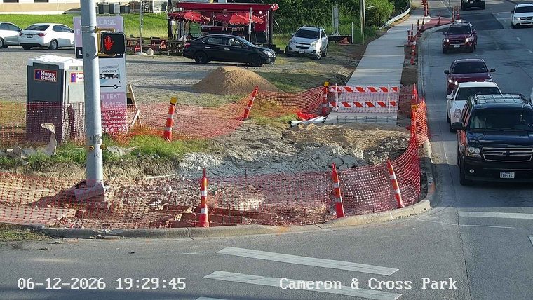 Construction debris and orange safety netting are visible on the roadside.