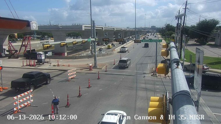 Police officer directing traffic near construction zone with barriers.