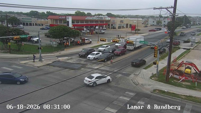 Construction workers and equipment are present at the Lamar & Rundberg intersection.