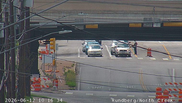 Person in road with traffic cones, possibly directing traffic.