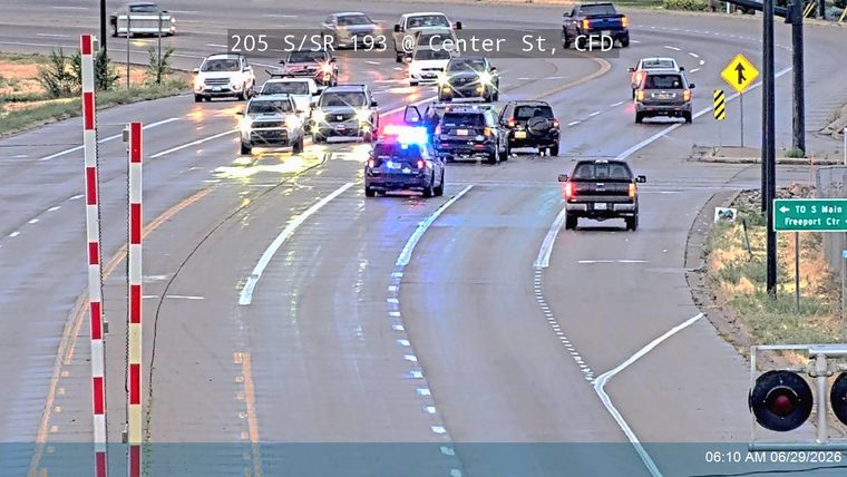 Police car with blue and red lights on in the left lane