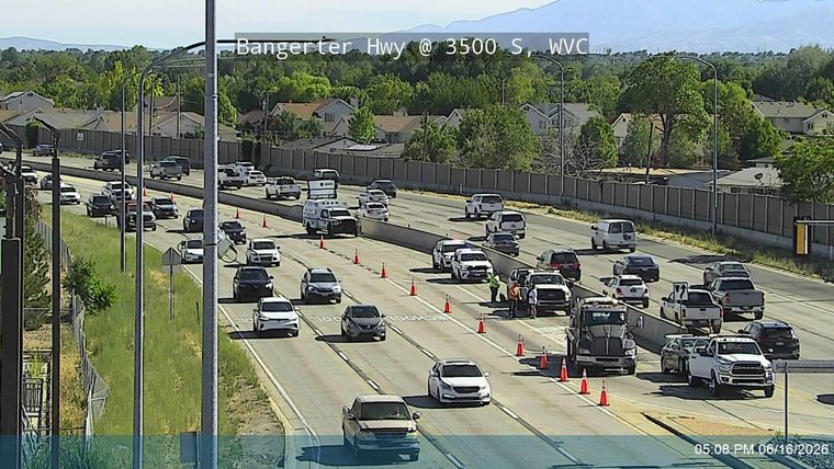 Emergency responders and traffic cones are present on the highway shoulder.